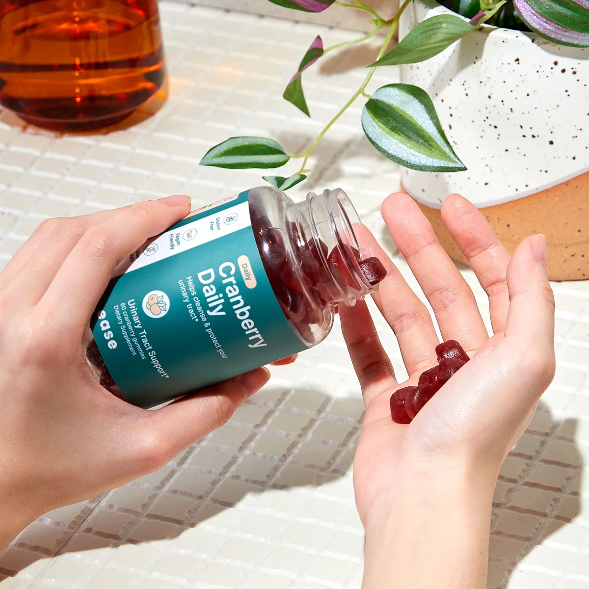 Pouring Ease cranberry gummies into a hand