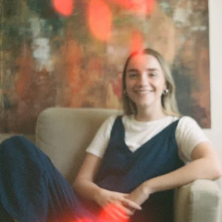 Guada smiling on a cream armchair