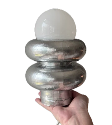 A chrome lamp with a frosted glass globe that Guada made